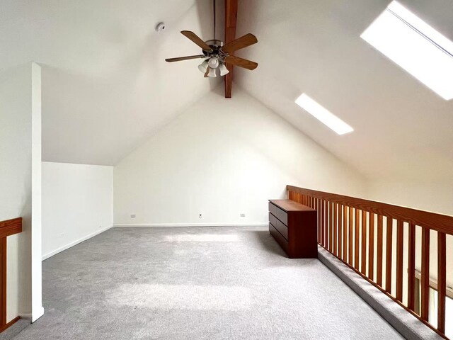 additional living space featuring lofted ceiling with skylight, ceiling fan, carpet floors, and baseboards