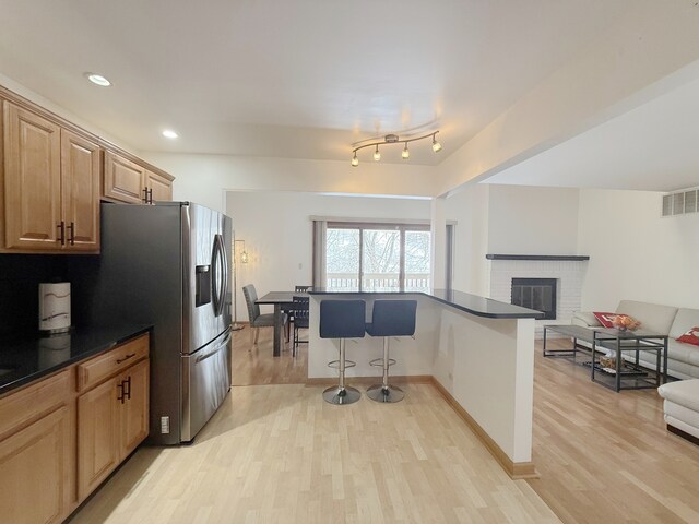 living area featuring baseboards, light wood-type flooring, and recessed lighting