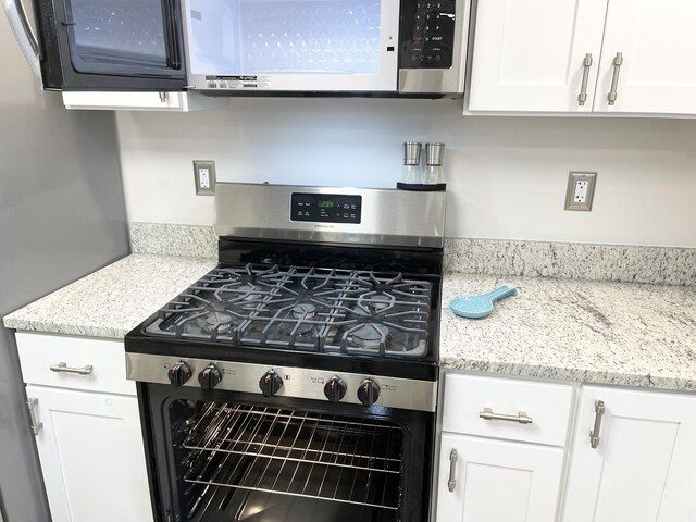 1299 Riverlane Dr, Bradley, IL 60915 - kitchen with white cabinetry, light stone counters, and stainless steel gas range oven