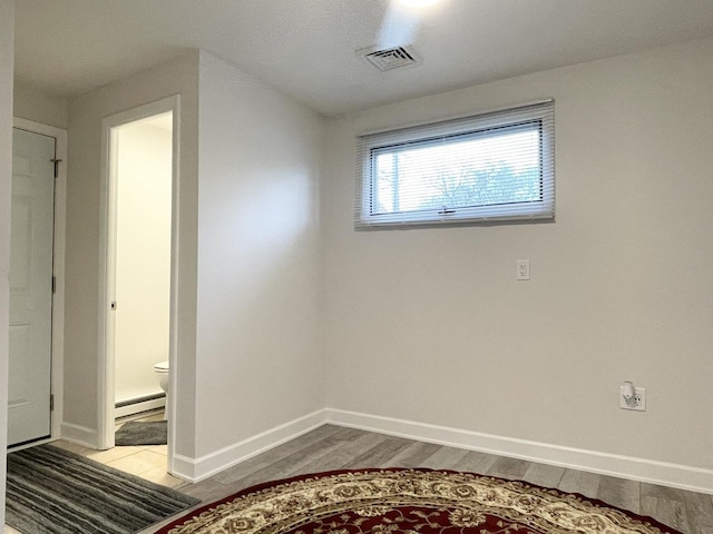 1299 Riverlane Dr, Bradley, IL 60915 - spare room featuring a baseboard radiator, visible vents, wood finished floors, and baseboards