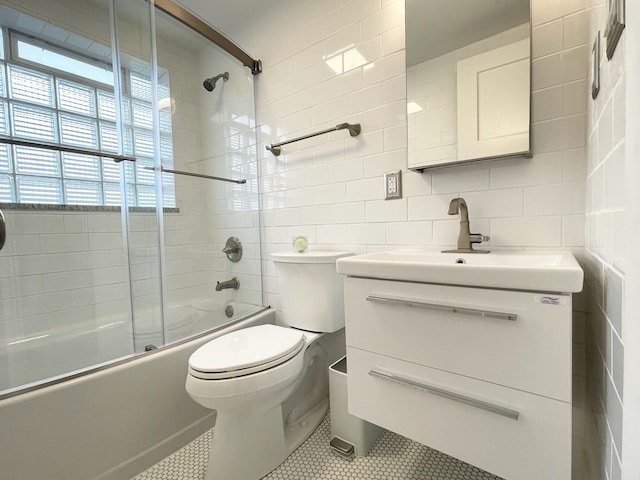 1299 Riverlane Dr, Bradley, IL 60915 - bathroom featuring tile patterned flooring, vanity, tile walls, toilet, and enclosed tub / shower combo
