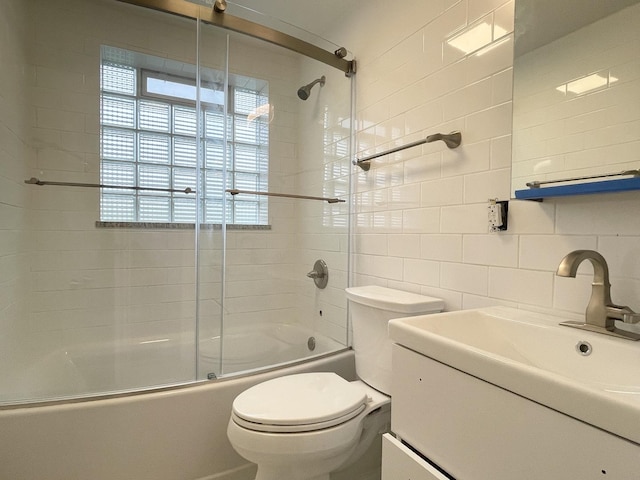 1299 Riverlane Dr, Bradley, IL 60915 - bathroom featuring tile walls, toilet, vanity, tasteful backsplash, and shower / bath combination with glass door