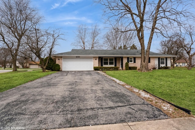 ranch-style home with a garage, brick siding, a front yard, and aphalt driveway