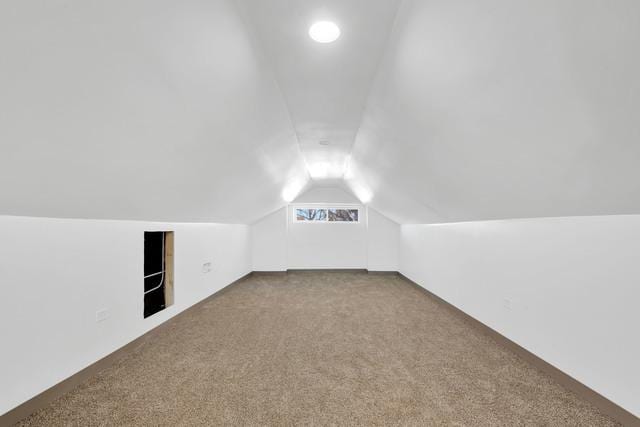 additional living space featuring carpet floors and vaulted ceiling