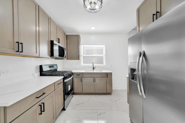 kitchen with marble finish floor, a sink, recessed lighting, stainless steel appliances, and light stone countertops