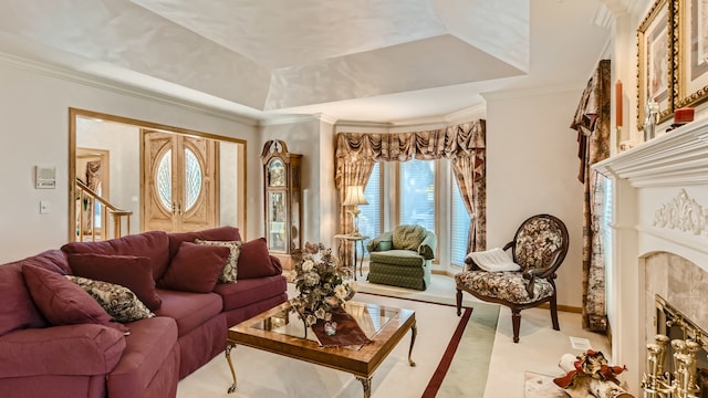 carpeted living area featuring crown molding, a tray ceiling, and a premium fireplace