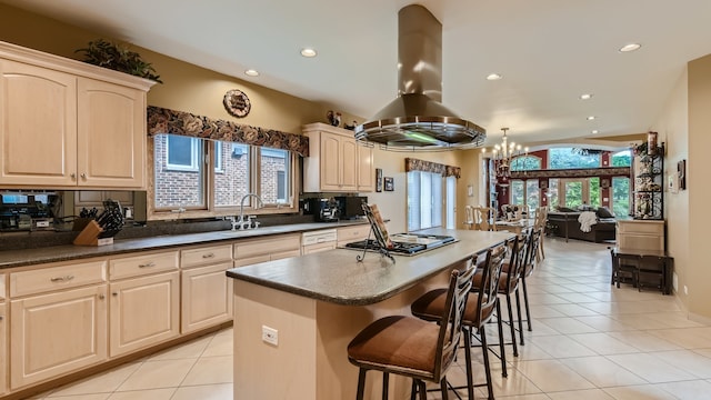 kitchen featuring a breakfast bar area, island exhaust hood, stainless steel gas stovetop, light tile patterned flooring, and a sink