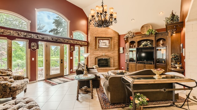 living room with light tile patterned floors, a brick fireplace, high vaulted ceiling, and an inviting chandelier