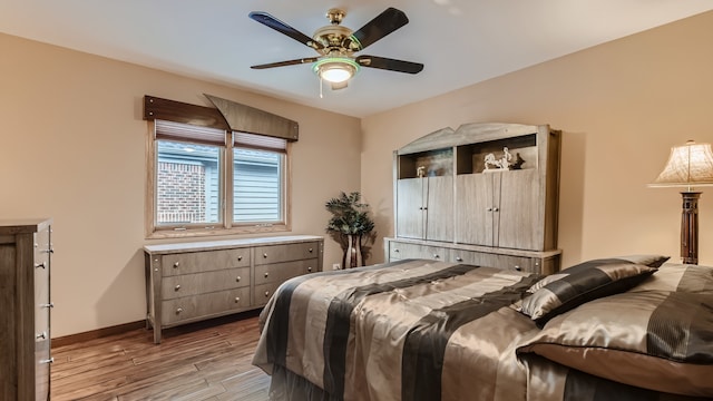 bedroom featuring light wood-type flooring, baseboards, and ceiling fan