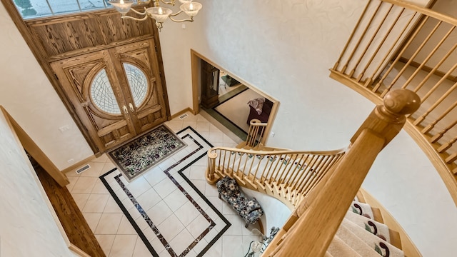entryway featuring visible vents, baseboards, a chandelier, and light tile patterned flooring