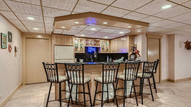 kitchen with tasteful backsplash, dark countertops, a peninsula, white refrigerator, and glass insert cabinets