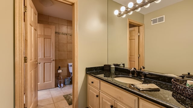 bathroom with visible vents, toilet, tile walls, tile patterned flooring, and vanity