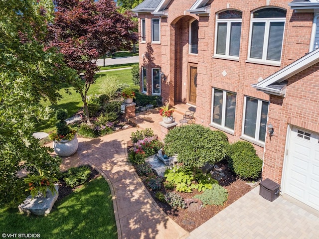 exterior space featuring a garage and brick siding