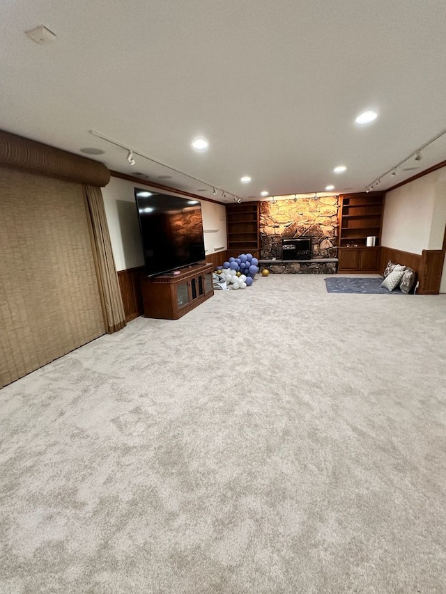 unfurnished living room featuring recessed lighting, a stone fireplace, built in features, and carpet