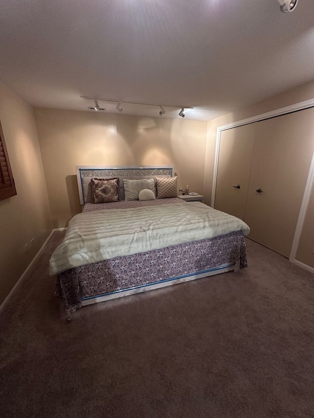 carpeted bedroom featuring track lighting
