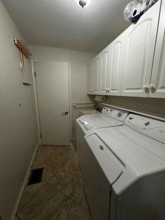 clothes washing area with visible vents, washing machine and dryer, baseboards, tile patterned floors, and cabinet space