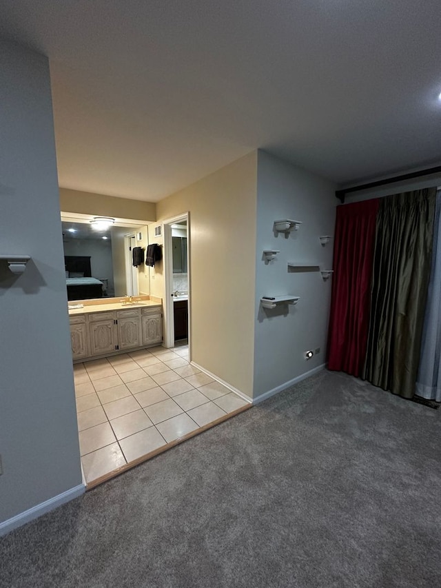 unfurnished living room with baseboards, light carpet, and a sink