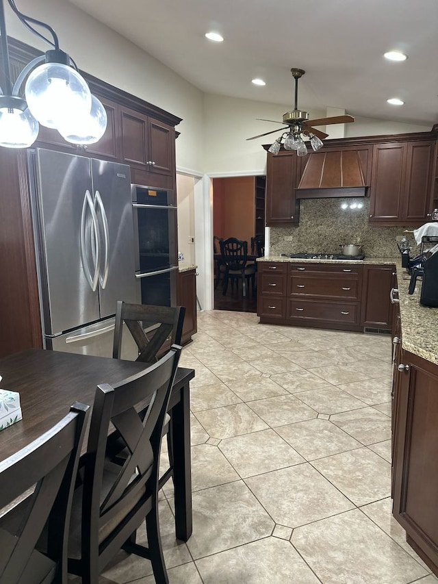 kitchen featuring ceiling fan, tasteful backsplash, light stone counters, stainless steel appliances, and light tile patterned flooring