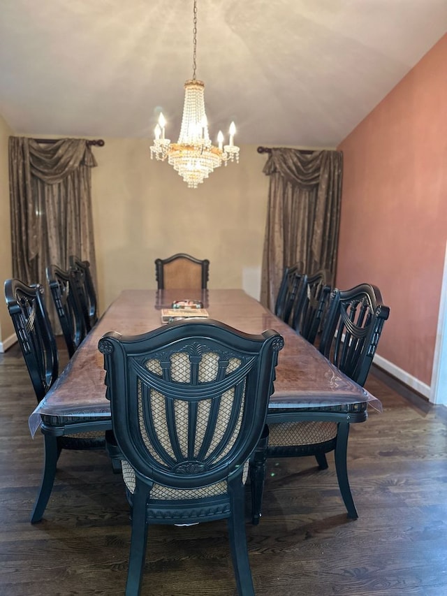 dining room with baseboards, wood finished floors, and a notable chandelier