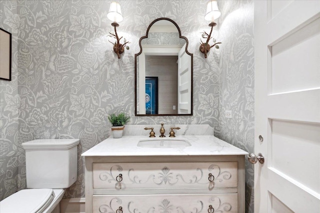bathroom featuring vanity and wallpapered walls