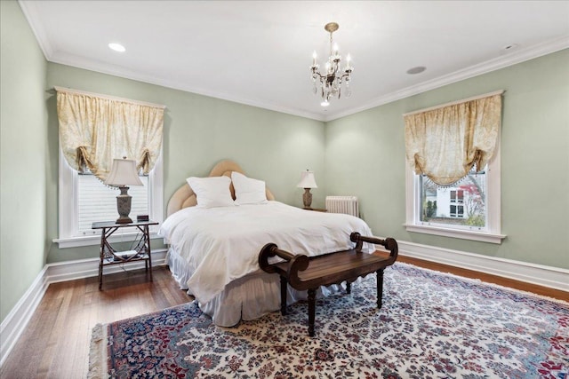 bedroom with wood finished floors, a notable chandelier, crown molding, baseboards, and radiator heating unit