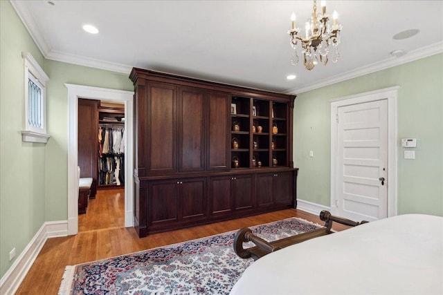 bedroom featuring light wood-type flooring, a chandelier, and ornamental molding