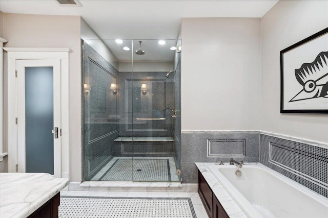 bathroom with vanity, visible vents, tile patterned floors, a shower stall, and a garden tub