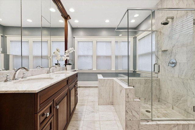 full bath with a stall shower, marble finish floor, and a sink