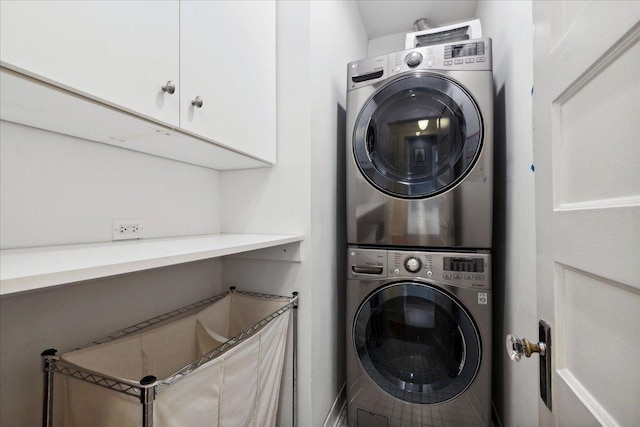 laundry area with cabinet space and stacked washer / drying machine