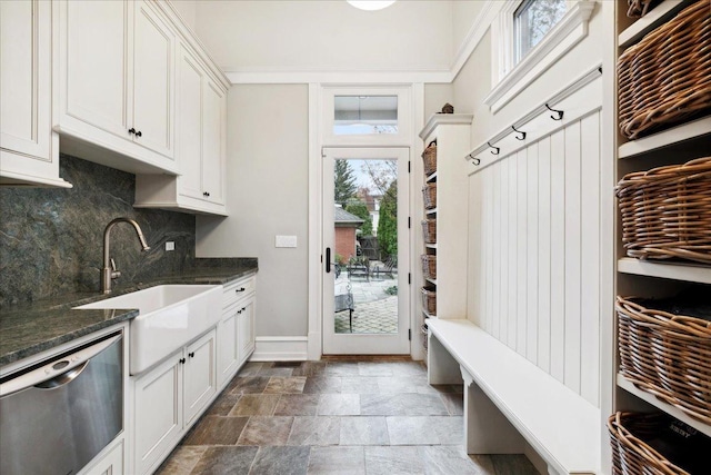 mudroom featuring baseboards, stone finish flooring, and a sink