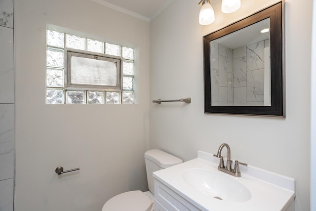 bathroom with vanity, crown molding, and toilet