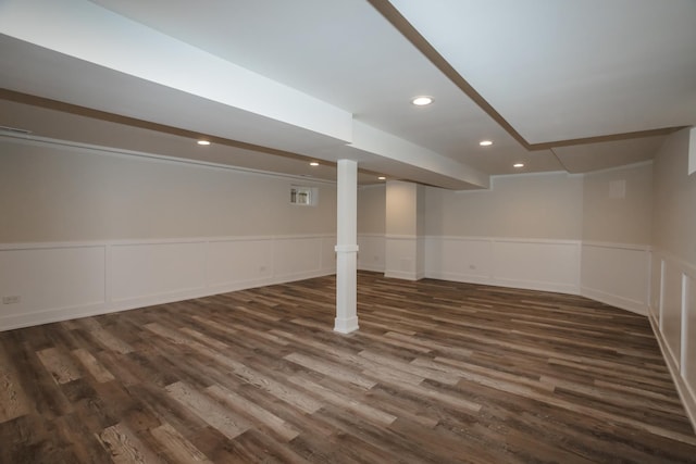 finished below grade area featuring recessed lighting, dark wood finished floors, and wainscoting
