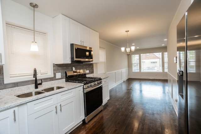 kitchen featuring a sink, light stone counters, white cabinetry, and stainless steel appliances