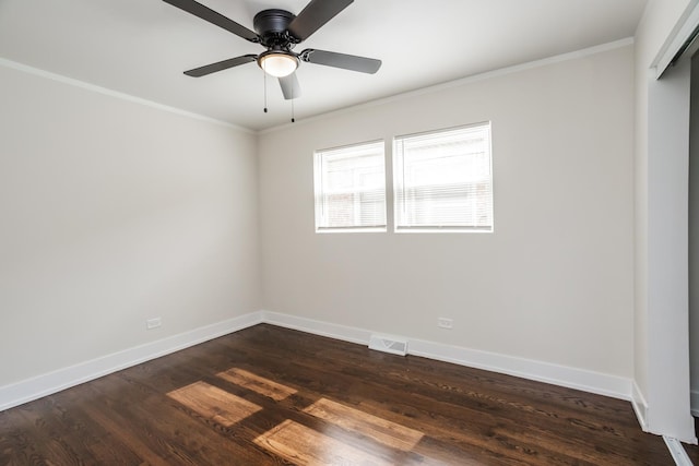 spare room with visible vents, crown molding, baseboards, ceiling fan, and dark wood-style flooring