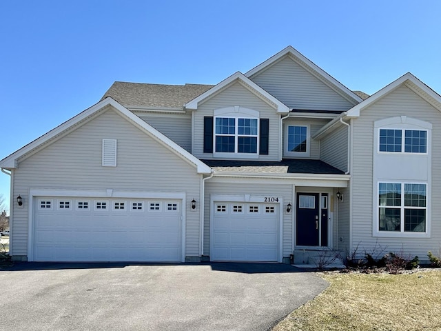 traditional home featuring aphalt driveway and a garage