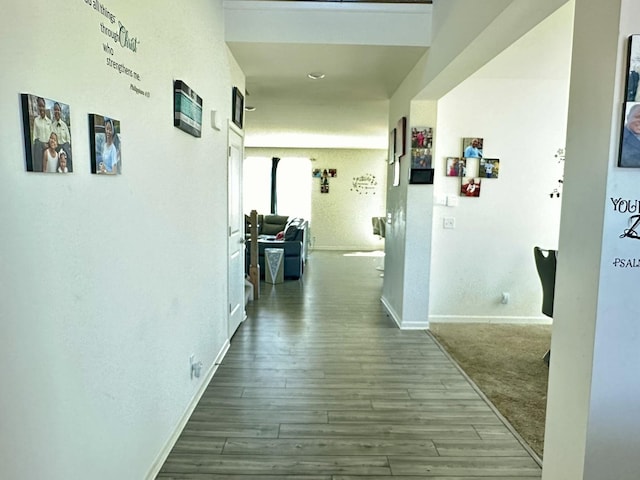 corridor featuring baseboards and wood finished floors