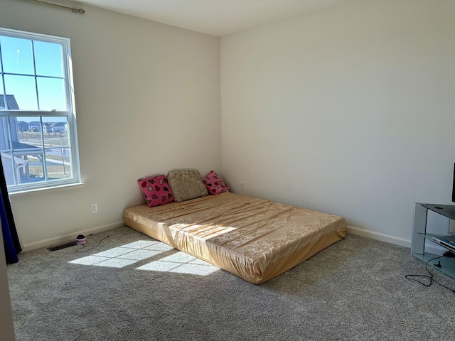carpeted bedroom featuring visible vents and baseboards