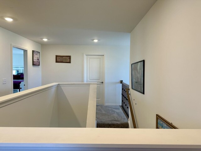 hallway featuring carpet flooring, an upstairs landing, recessed lighting, and baseboards
