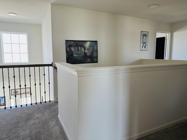 hall with baseboards and carpet floors
