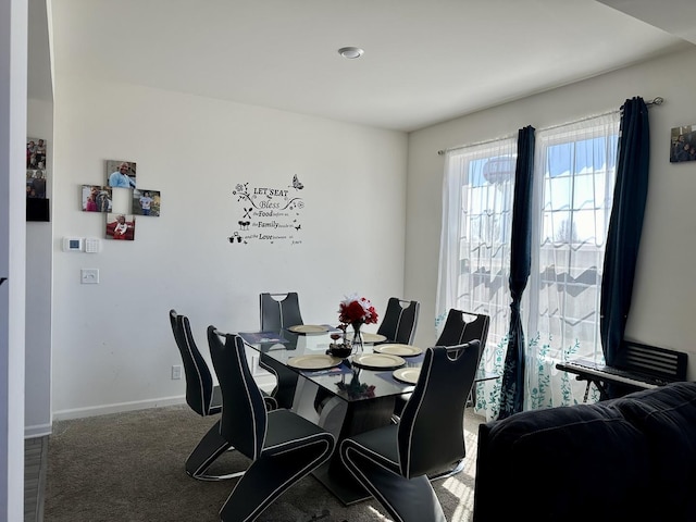 carpeted dining space with baseboards