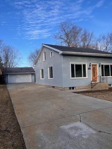 view of side of home with a garage, an outbuilding, and concrete driveway