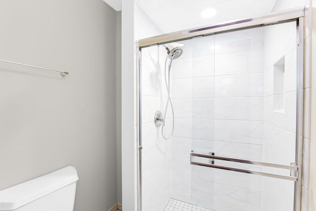 bathroom featuring toilet and a stall shower