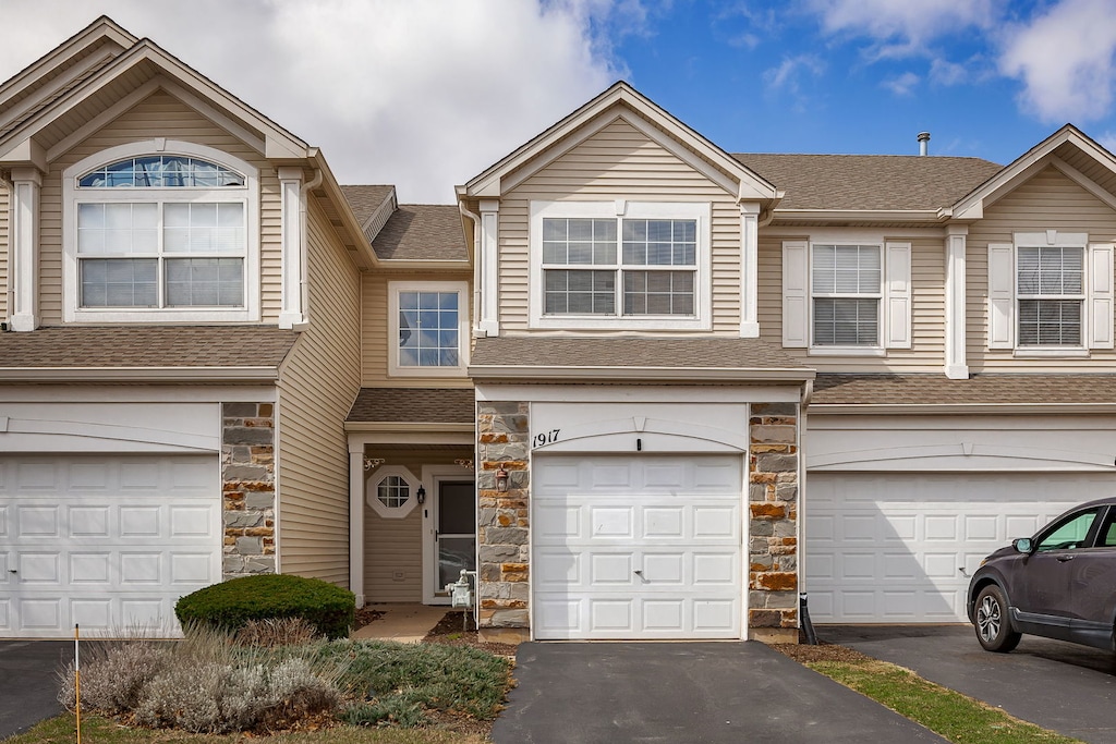 1917 Misty Ridge Ln, Aurora, IL 60503 - multi unit property with stone siding, a shingled roof, a garage, and driveway