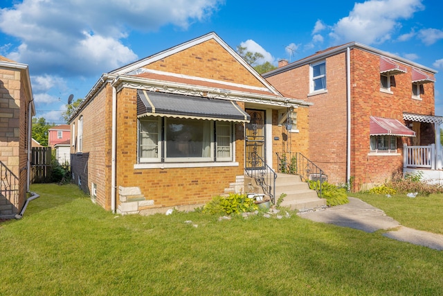 view of front of house with brick siding, a front yard, and fence