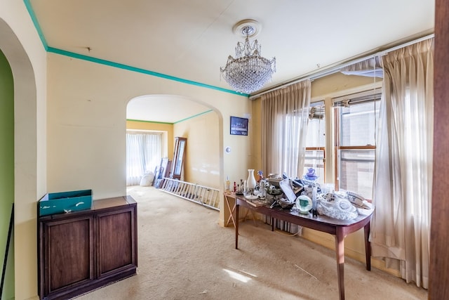 dining space featuring arched walkways and light colored carpet