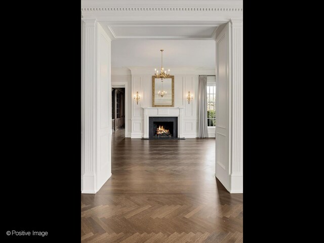 330 S County Line Rd, Hinsdale, IL 60521 - unfurnished living room with a chandelier, ornamental molding, a decorative wall, and a fireplace
