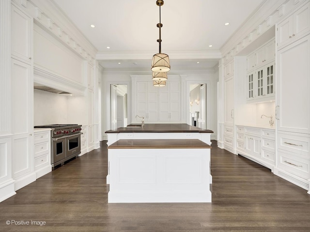 330 S County Line Rd, Hinsdale, IL 60521 - kitchen with range with two ovens, a decorative wall, white cabinets, an island with sink, and dark countertops