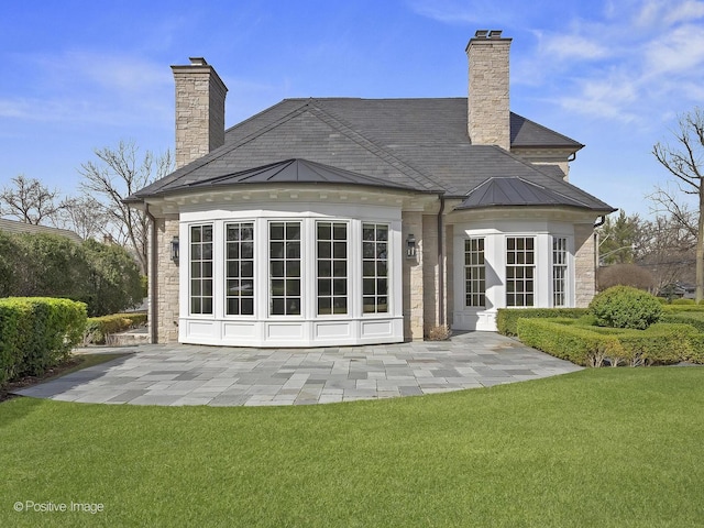 330 S County Line Rd, Hinsdale, IL 60521 - rear view of house featuring a chimney, a yard, a patio area, and stone siding