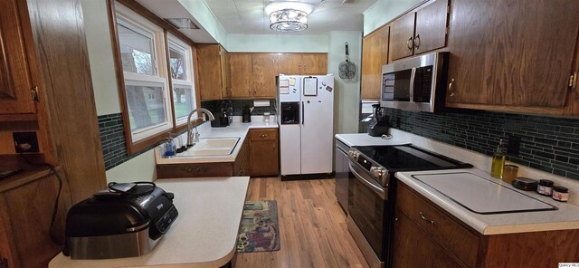 508 N Fayette, Carthage, IL 62321 - kitchen featuring stainless steel appliances, a sink, light wood-type flooring, backsplash, and light countertops