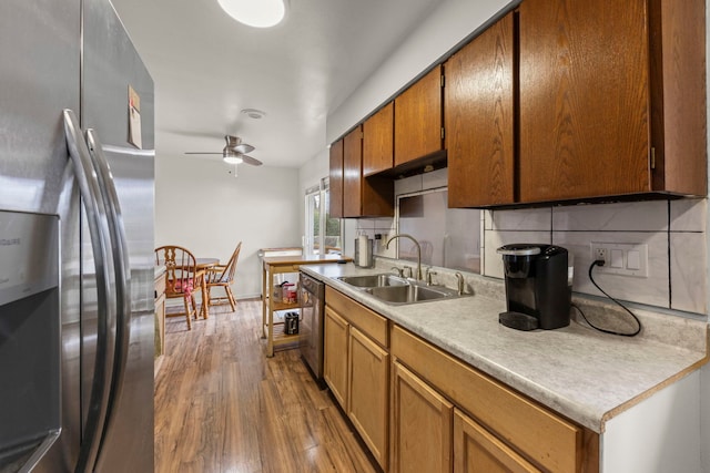 kitchen with a sink, tasteful backsplash, appliances with stainless steel finishes, and a ceiling fan